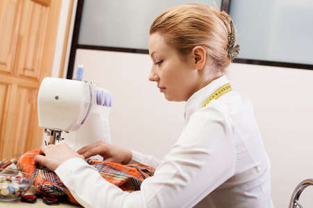 A sewer working on the sewing machine.の写真素材