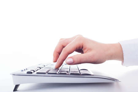Female hand on the black keyboard on the white.の写真素材