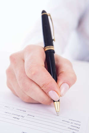 Hand filling out the form on the white.