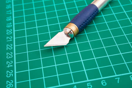 Closeup of paper-knife on the mat for cutting paperの写真素材