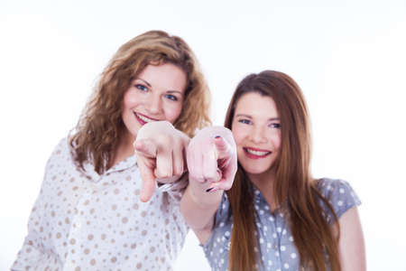 Girls pointing her fingers at you on the white backgroundの写真素材