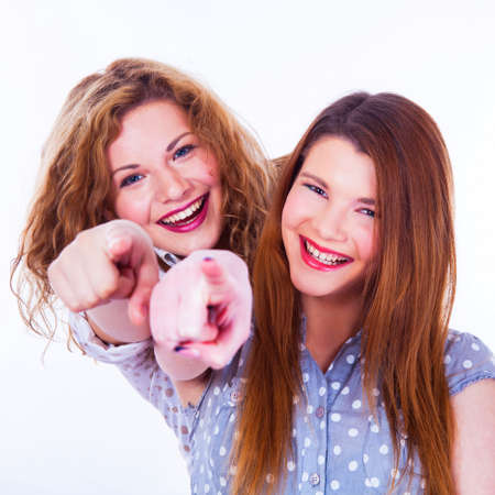 Girls pointing her fingers at you on the white backgroundの写真素材