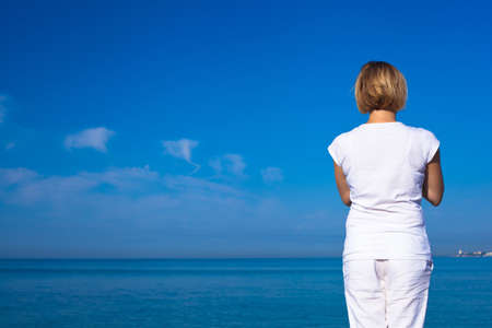 Yoga woman doing exercises at the seafront.の写真素材