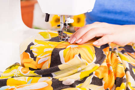 A tailor working on sewing machine from home