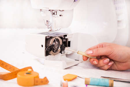 Tailor's working in a workroom  repairing a sewing machine