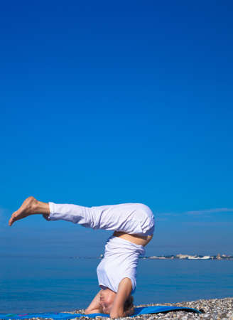 Yoga woman doing exercises at the seafront.