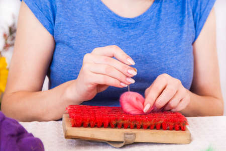 Felting activity, woman working with a felting needle and wool