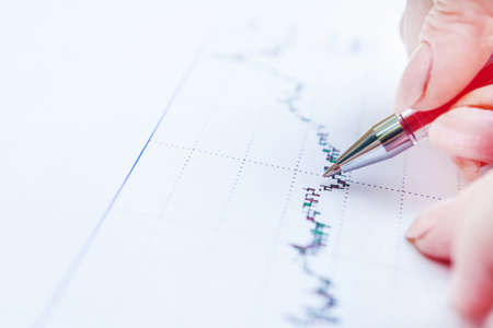 Image of female hand pointing at business document at the officeの写真素材