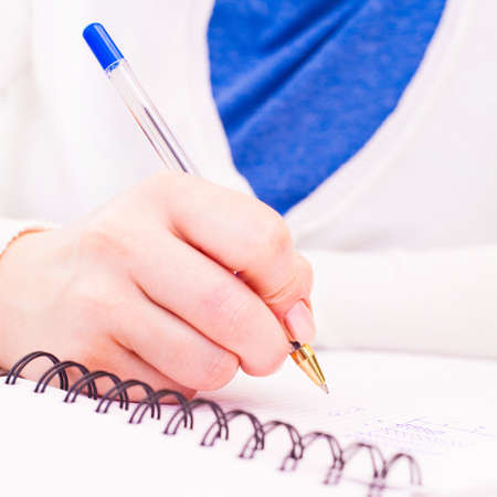 Business Woman Writing with pen in notepad at the office