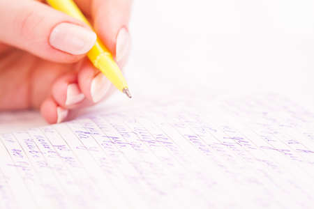 Business Woman Writing with pen in notepad at the office