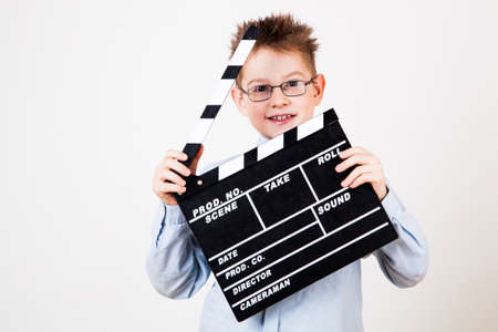 Little boy holding clapper board in hands.の写真素材