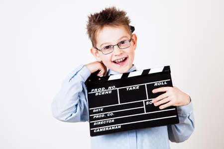 Little boy holding clapper board in hands.