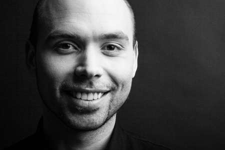 Young handsome man with great smile on the black backgroundの写真素材