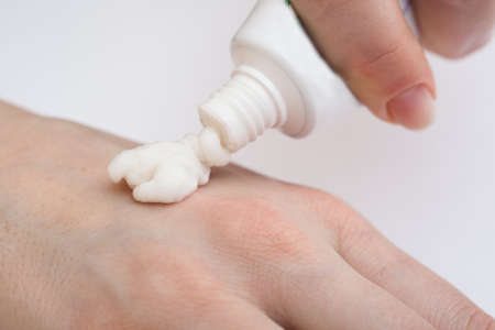 Closeup of  female hands applying creamの写真素材