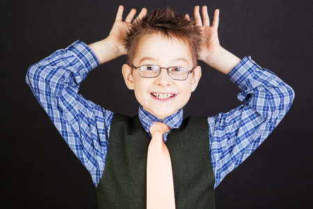 Young funny boy grimacing over the black