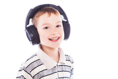 The young boy is smiling and listening to musicの写真素材
