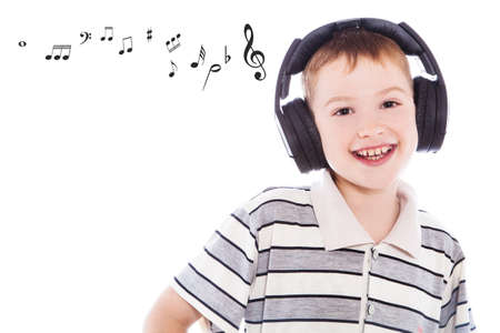 The young boy is smiling and listening to musicの写真素材