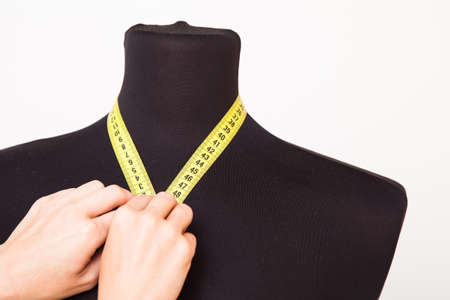Woman tailor making measurements on the mannequinの写真素材
