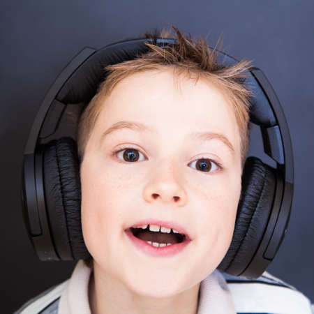 The playful boy  listening to music in headphones