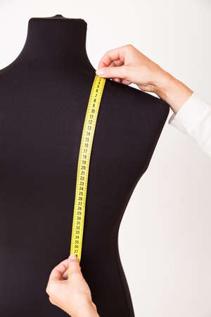 Woman tailor making measurements on the mannequinの写真素材