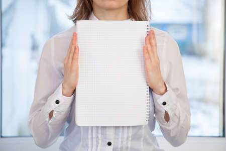 Woman holding blank ring-bound notebookの写真素材