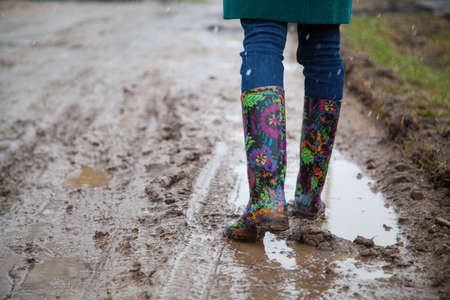 Woman with rain boots jumpsの写真素材