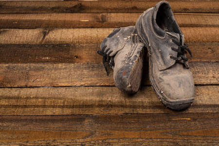 Grunge old boots on  the wood backgroundの写真素材