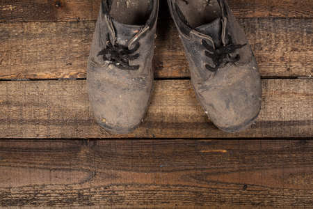 Grunge old boots on  the wood backgroundの写真素材