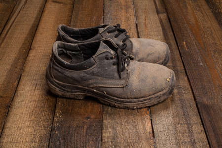 Grunge old boots on  the wood backgroundの写真素材
