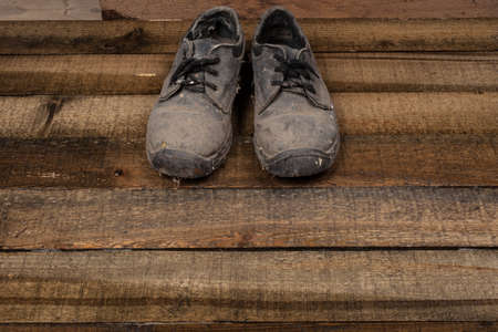 Grunge old boots on  the wood backgroundの写真素材