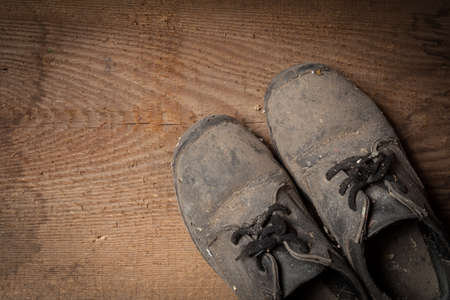 Grunge old boots on  the wood backgroundの写真素材