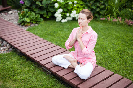 Yoga woman in the garden on the wooden floorの写真素材