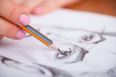 Closeup of drawing mans portrait at the deskの写真素材