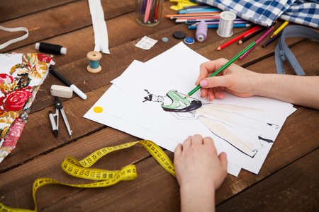 Fashion designer drawing new models of clothes