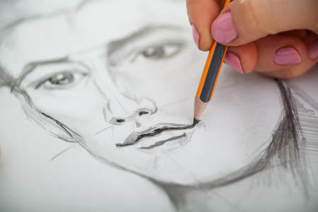 Closeup of drawing mans portrait at the deskの写真素材