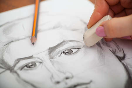 Closeup of drawing mans portrait at the desk