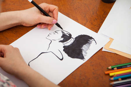 Closeup of drawing womans portrait at the desk