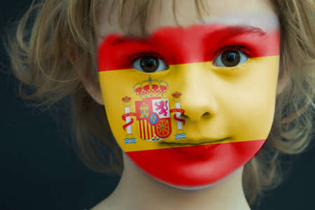 Portrait of a child with a painted Spanish flagの写真素材