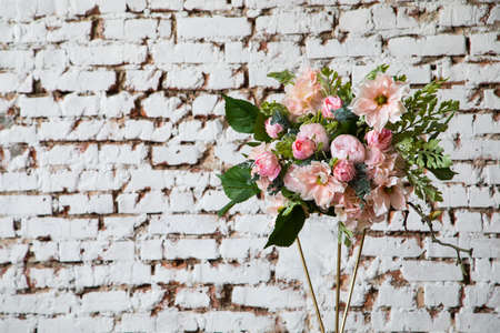 Luxury floral arrangement of pink and white flowers on the white wall.