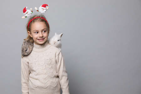 happy little girl with adorable rabbits at christmas time.の写真素材