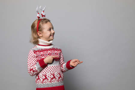Funny kid with Christmas band. Cheerful smiling little girl .の写真素材