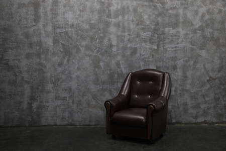 Modern lounge chair against a gray wall.の写真素材