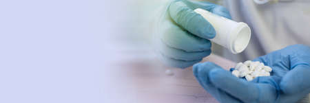 Medicine pills or capsules in hand, palm or fingers.