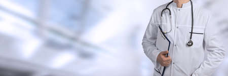 Doctor man over blue blurred hospital backgroundの写真素材