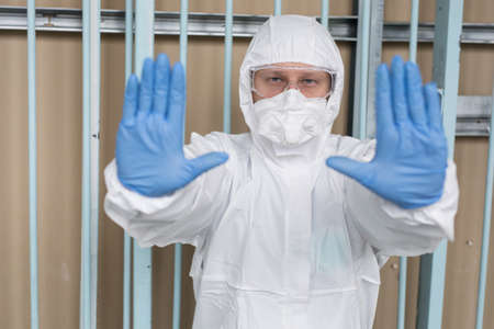 A man in a protective suit evacuates peopleの写真素材