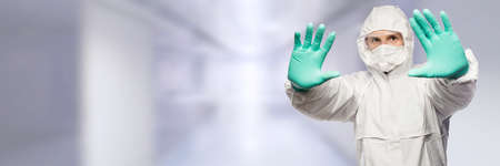 A man in a protective suit says stop the virusの写真素材