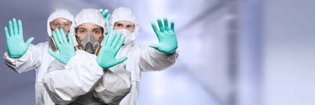 Woman and men in a chemical protective clothing and antigas mask .