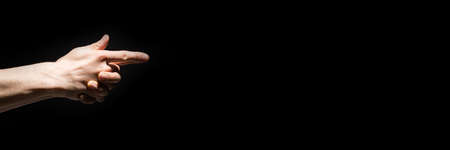 male hands pointing out fingers sidewise over black backgroundの写真素材