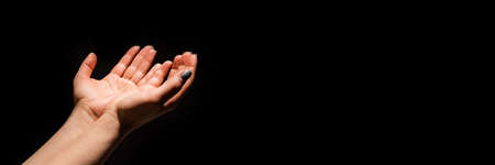 Male hands out palms up in plea or want against blackの写真素材