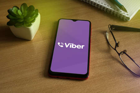Minsk 12.05.2020. Smartphone on a wooden table with a image of Viber.のeditorial素材